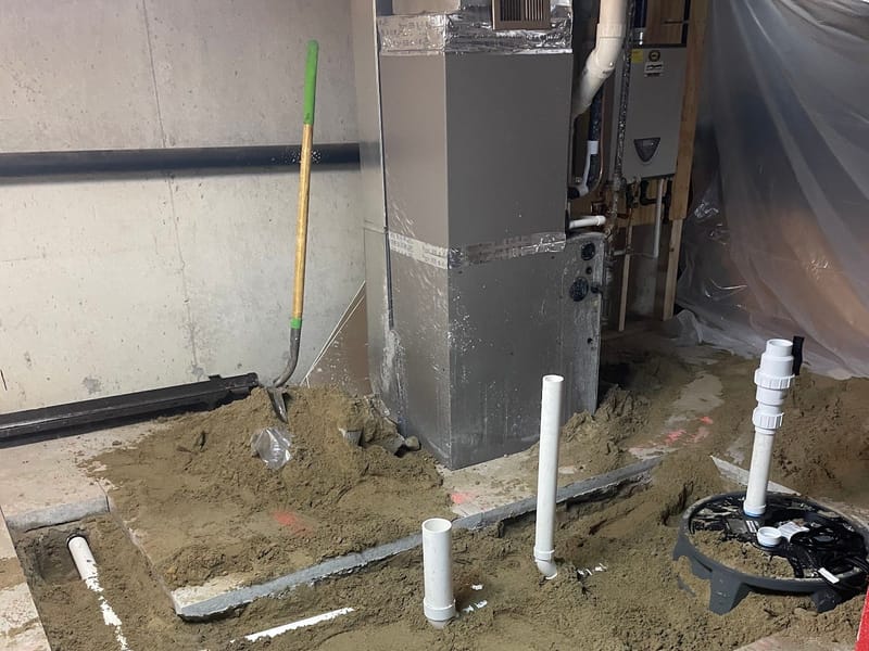 New furnace with PVC venting being installed in a basement
