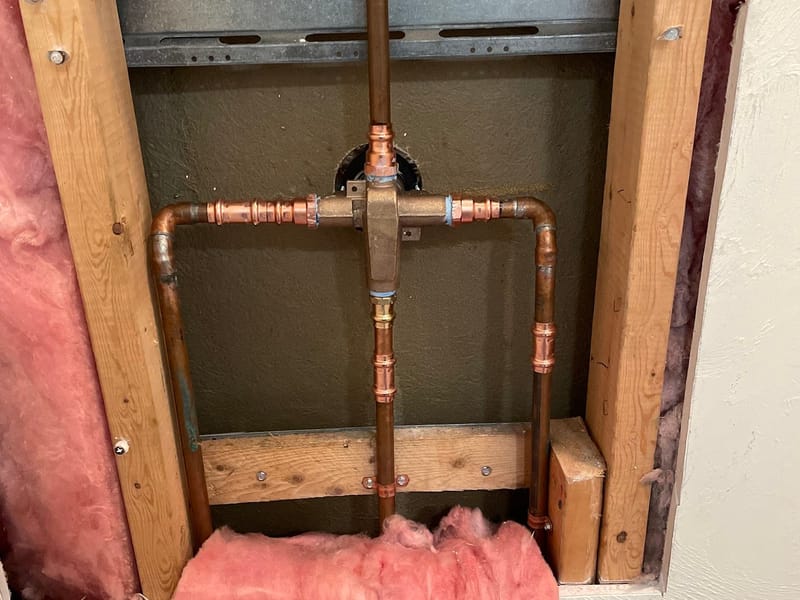 New copper supply lines and a shower valve roughed into an open wall