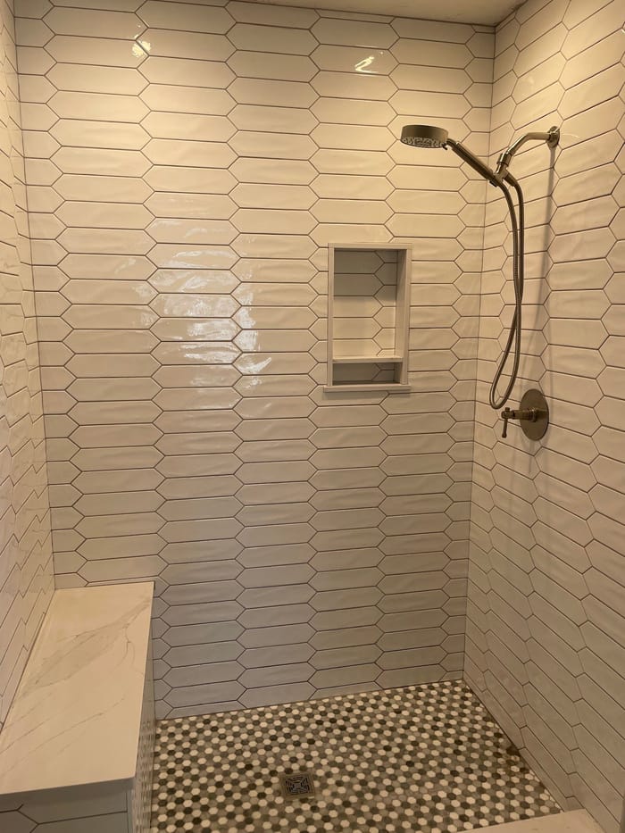 Tiled shower with a niche, bench and mosaic floor